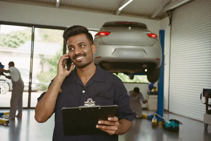 Service advisor taking a customer call on the workshop floor